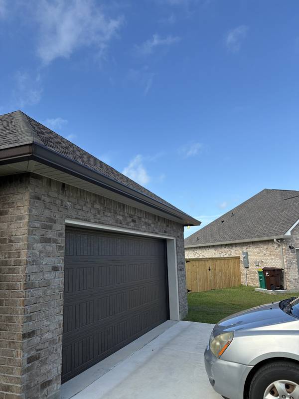 Dark bronze gutters over a brick garage